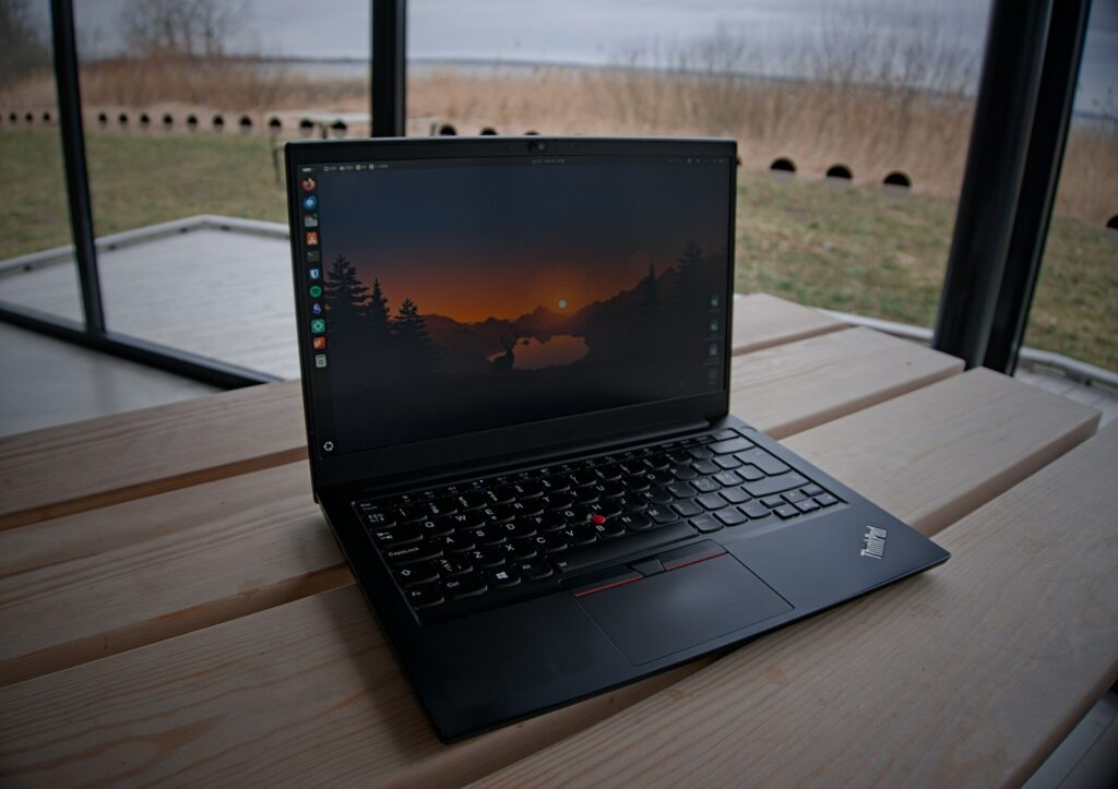 Lenovo ThinkPad steht aufgeklappt auf einem Holztisch