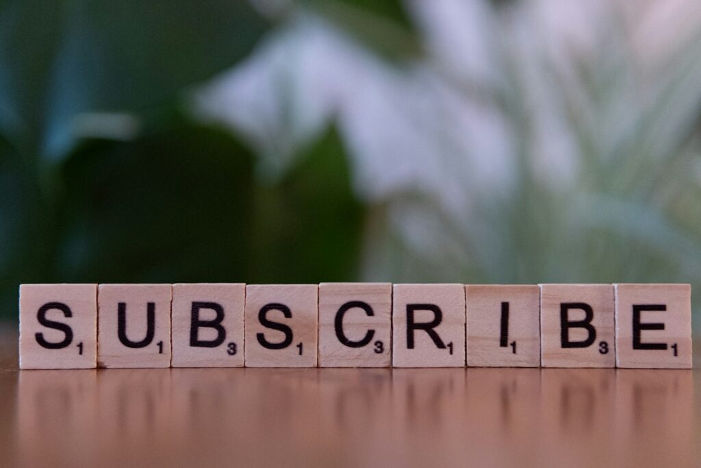 Holzbuchstaben bilden das Wort SUBSCRIBE
