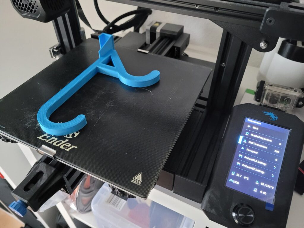 Blau gedruckter Haken auf dem Glasdruckbett des Ender 3 V2
